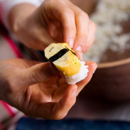 Preparing egg nigiri with rice and japanese omelette.の写真素材