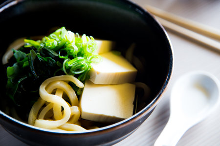 Miso soup is a Japanese soup made from a dashi brother and miso paste, which gives it its name. It can be served with tofu or noodles.の写真素材