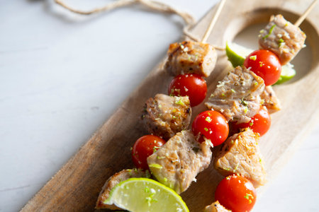 Grilled chicken skewer with vegetables and limeの写真素材