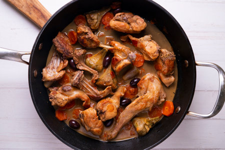 Rabbit cooked with baked artichokes. Traditional Spanish cover.の写真素材