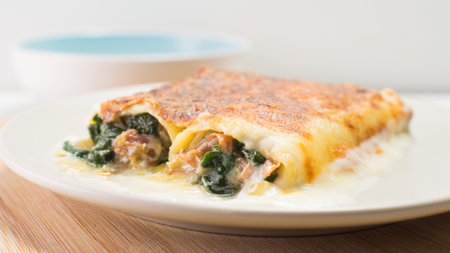 Cannelloni pasta stuffed with meat, vegetables and spinach gratin in the oven. Traditional Christmas recipe in Spain.の写真素材