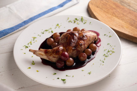 Rabbit thigh with red wine sauce and grapes.の写真素材