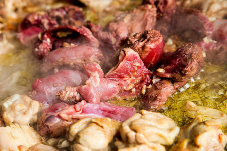 Cooking the authentic Valencian Spanish paella with chicken and rabbit.