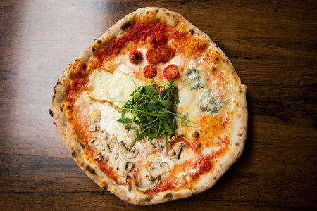 Four Seasons Pizza. Neapolitan pizza with tomato sauce, cheese, ham, mushrooms and vegetables. Authentic Italian recipe.の写真素材