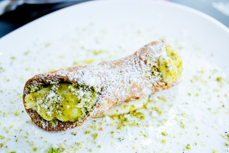 The cannolo is a typical sweet from the Italian region of Sicily, where it originates from. It consists of a rolled dough in the shape of a tube filled with ricotta.の写真素材