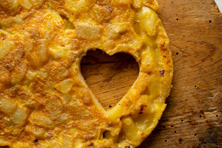 Spanish potato omelette cut into the shape of a heart. Traditional tapa recipe with egg, potato, onion.の写真素材