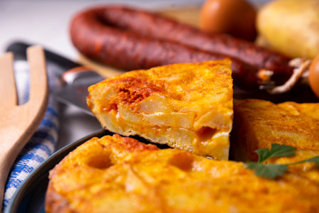 Spanish potato omelette with chorizo. Traditional tapa recipe with egg, potato and onion.の写真素材