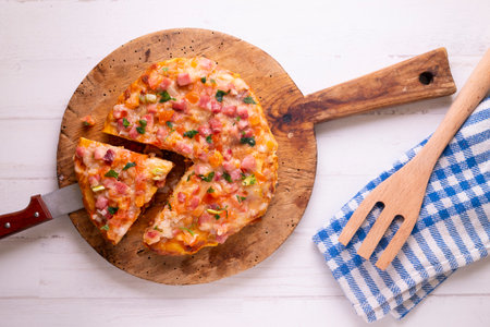 Spanish potato omelette with a topping of vegetables and ham. Traditional tapas recipe.の写真素材