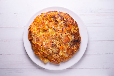 Spanish omelette with roasted sweet potatoes. Traditional tapa recipe with egg, potato and onion.の写真素材