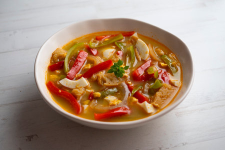 Red and green pepper soup with tomato and onion.