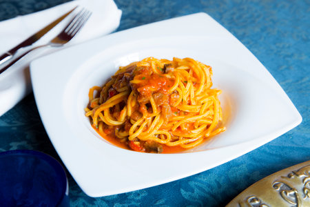 Spaghetti al pomodoro prepared with pasta, olive oil, fresh tomatoes, basil and other fresh ingredients.の写真素材