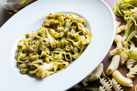 Spaghetti with pesto. Pesto is a typical seasoning or sauce originating from Liguria. Its main ingredient is basil or better, Genovese basil.の写真素材