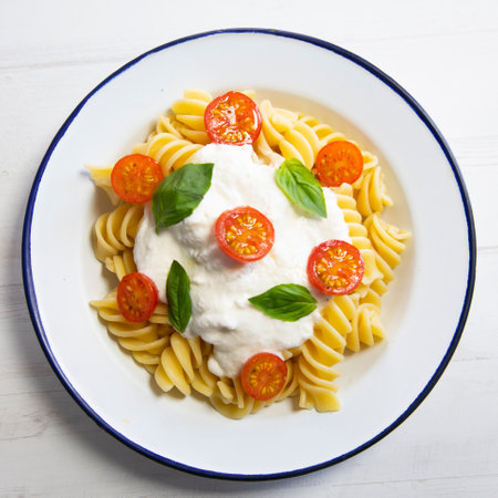 Fussili with mozzarella cheese sauce and cherry tomatoes.の写真素材