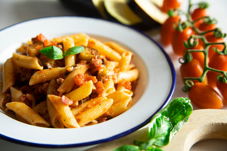 Pasta alla norma. Made with maccheroni, eggplant, tomatoes, fresh basil and grated ricotta salata.の写真素材