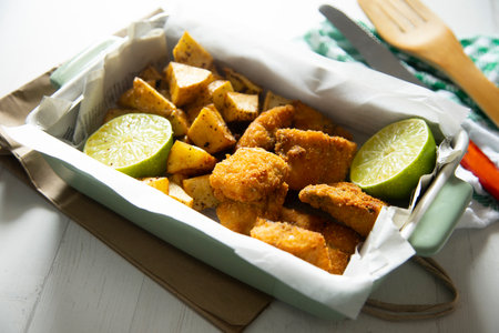 Fish and chips is a popular hot dish consisting of fish fried in a crispy batter, served with chips.の写真素材