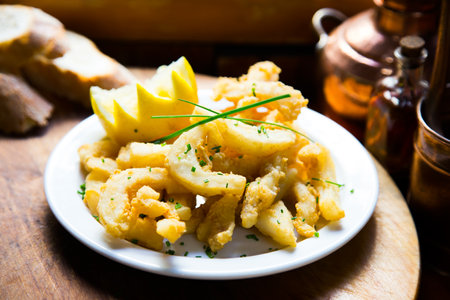 Rabas a la romana Breaded squid leg tapa served with lemon. Traditional Spanish cover.