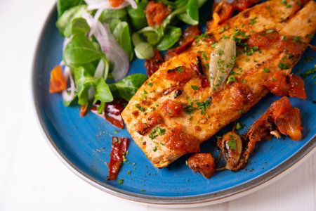 Pomfret with tomato sauce and salad.の写真素材