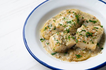 Baked hake cooked with green sauce and clams. Traditional northern Spanish recipe.の写真素材