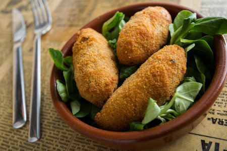 The croquette is a portion of dough made from a dense sauce such as bechamel and a mincemeat of various ingredients, which has been coated in egg and breadcrumbs, and fried in oil.の写真素材