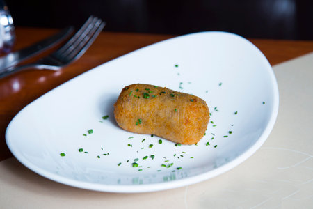 The croquette is a portion of dough made from a dense sauce such as bechamel and a mincemeat of various ingredients, which has been coated in egg and breadcrumbs, and fried in oil.の写真素材