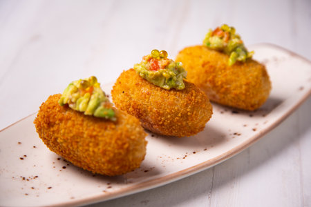 Iberico ham croquette with guacamole on top. Premium Spanish tapa.