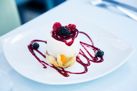 Cheesecake with red fruit sauce and fresh fruit such as raspberries, blueberries or strawberries.
