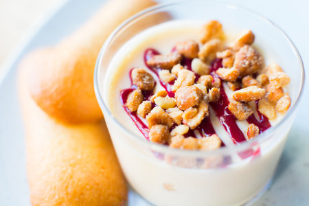 Cheesecake with red berries sauce served in a glass with different toppings.