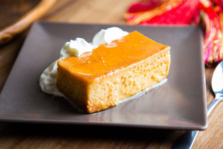 Egg flan with some wiped cream on the side.