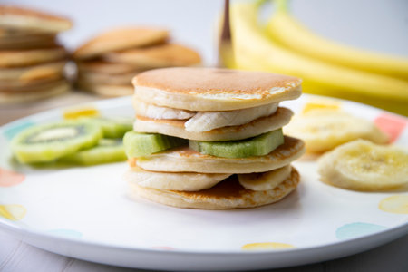 Pancakes with fresh fruit like banana, strawberries or kiwi with a dark chocolate covered.の写真素材