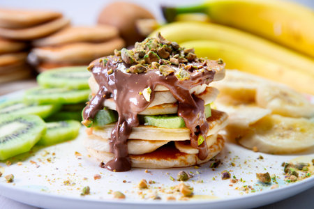 Pancakes with fresh fruit like banana, strawberries or kiwi with a dark chocolate covered.