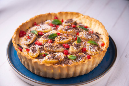 <p>Banana yogurt sponge cake with pieces of fresh fruit and chocolate on top</p>の写真素材