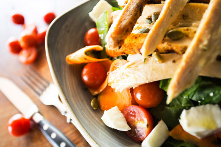 A Caesar salad is a salad of romaine lettuce, croutons, and chicken with lemon juice, olive oil, egg, Worcestershire sauce, anchovies, garlic, Dijon mustard, Parmesan cheese, and bの写真素材