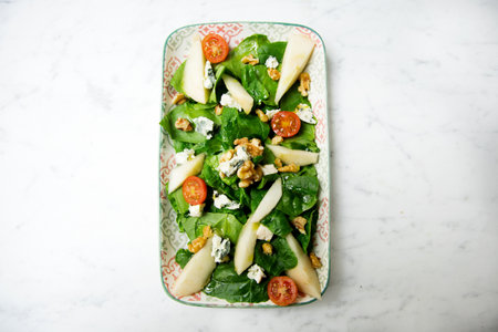 Delicious Italian green salad with pear, mozzarella and tomatoes.の写真素材