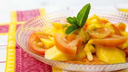 Delicious salad with mango and tomatoes.の写真素材