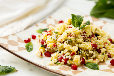 Couscous salad with pomegranate and mint leaves.の写真素材