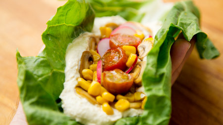 Hummus on a salad leaf with corn and radish.の写真素材