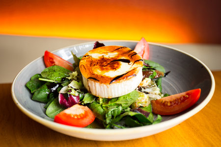 Delicious and healthy green salad with gratin goat cheese.の写真素材