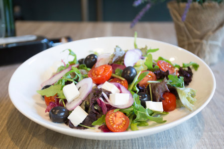 Delicious and healthy salad with a variety of cheeses and tomatoes.の写真素材