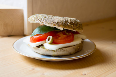 Delicious mozzarella sandwich on bagel bread. A bagel is a bread traditionally made from wheat flour and usually has a hole in the center.の写真素材