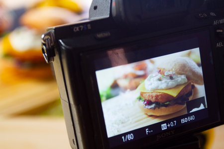 A person is using a camera to take a picture of food and beverage on a table.の写真素材