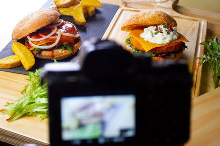 A person is using a camera to take a picture of food and beverage on a table.の写真素材