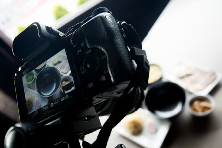 A person is using a camera to take a picture of food and beverage on a table.の写真素材