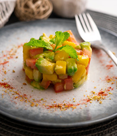 Avocado, mango and tomato tartare on a table with Christmas decorations.の写真素材