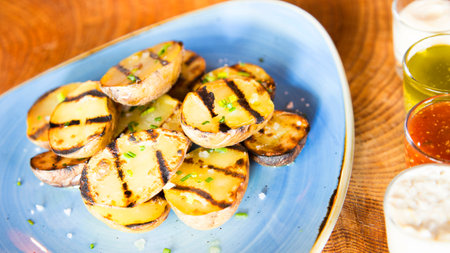 Papas bravas, are a typical preparation of bars in Spain consisting of potatoes cut into large cubes, fried in olive oil and seasoned with salsa brava, which is a spicy sauce.の写真素材