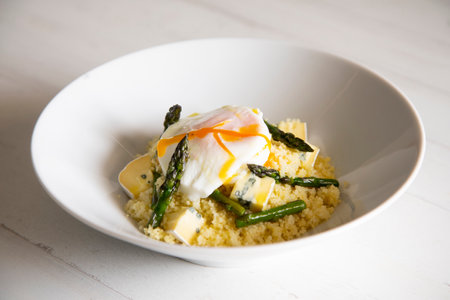 Couscous dish with a poached egg and green asparagus.の写真素材