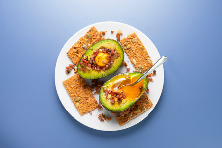 Breakfast recipe with avocado stuffed with egg and ham.