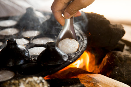 Woman preparing coconut thai desserts. Kanom krok is a tasty Thai coconut milk based mini pancakes popular street food as well.の写真素材