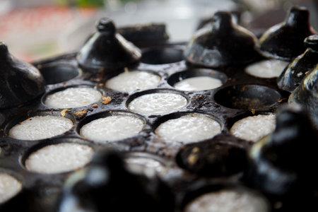 Woman preparing coconut thai desserts. Kanom krok is a tasty Thai coconut milk based mini pancakes...
