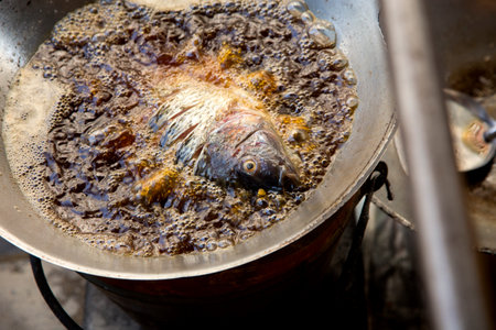 Fish in a pan with boiling oil at a street food stall in Bangkok, Thailand.の写真素材