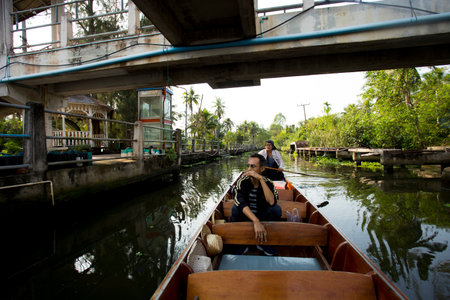Amphawa, Thailand; January 1, 2023: A man and a woman taking a canoe through the Amphawa floating market.のeditorial素材